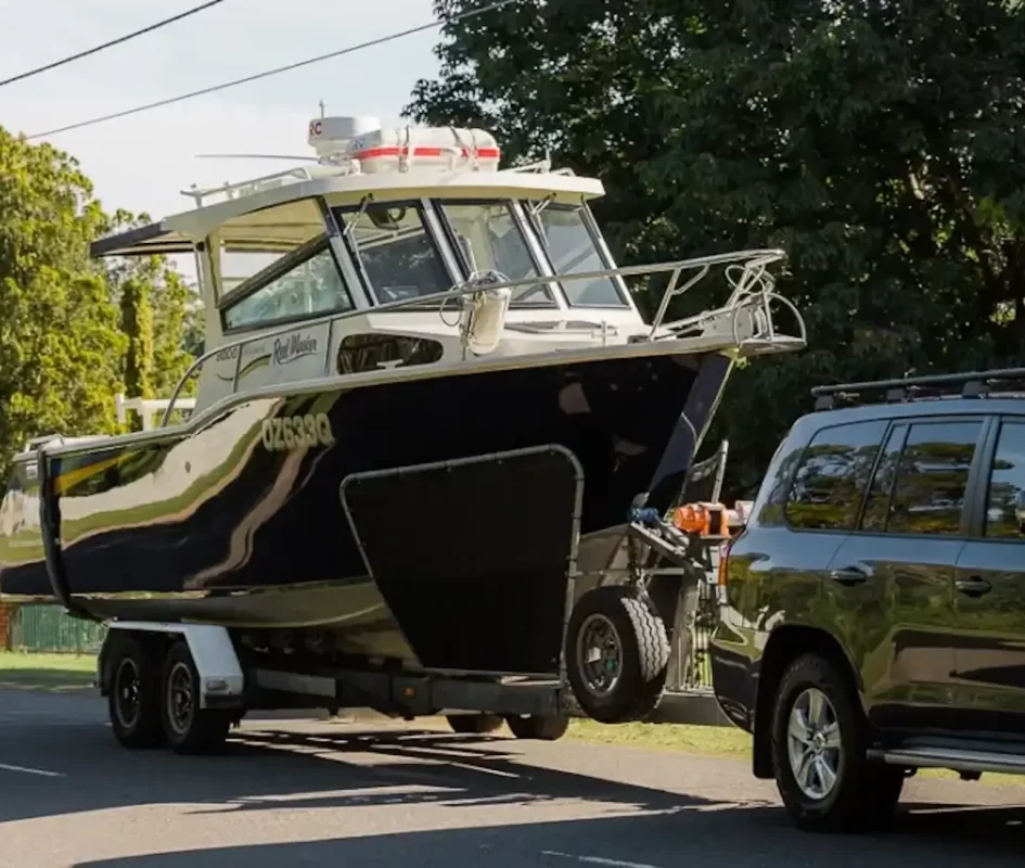 Boat being towed on trailer by SUV, representing Smarter Towing company innovative trailer monitoring technology