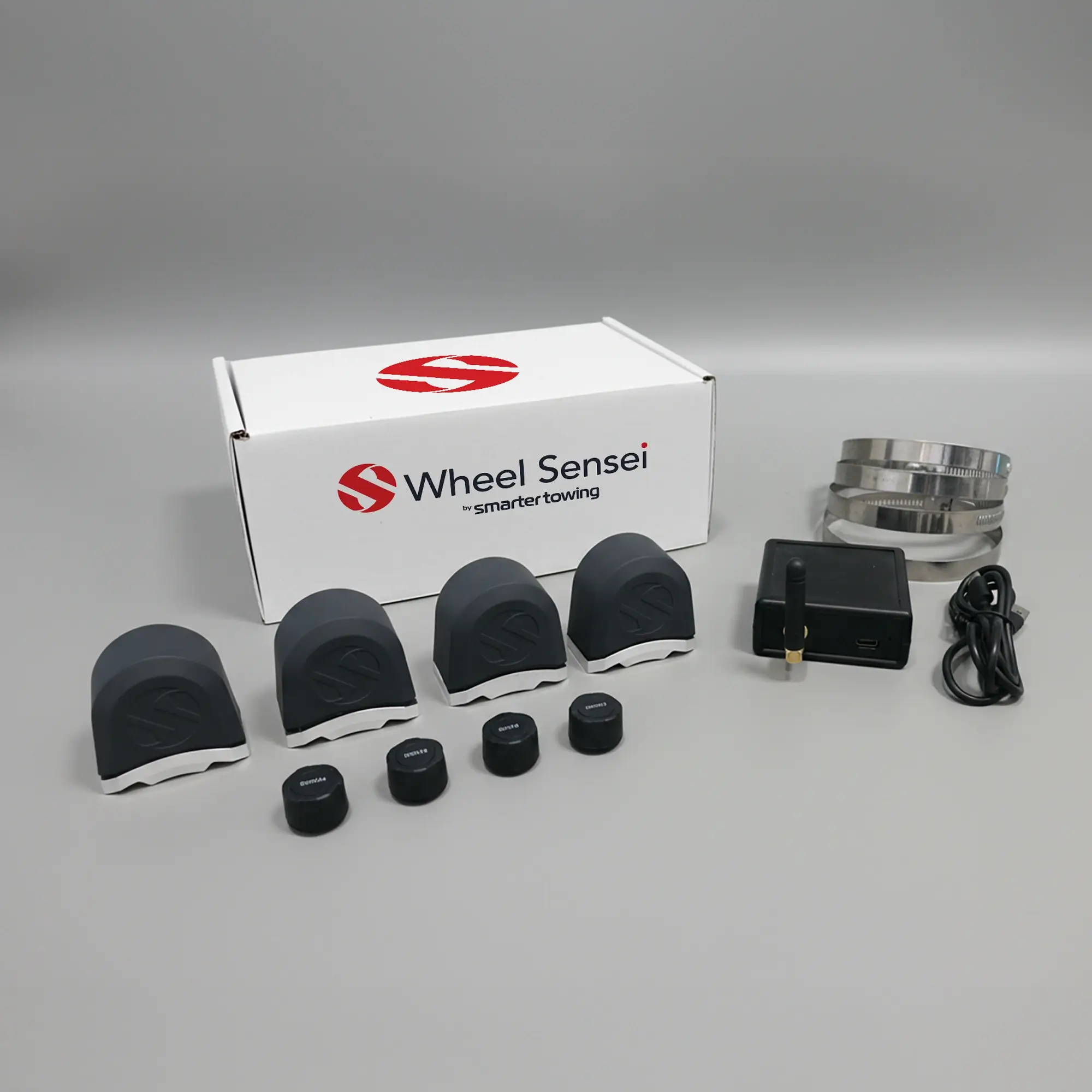 Dual Axle TPMS Smarter Towing Kit by Smarter Towing includes 4 x wheel sensei sensor units, 4 x pressure sensors, ring clamps, data box, USB-C cable and activation code for real-time tyre pressure and bearing monitoring on trailers and caravans.