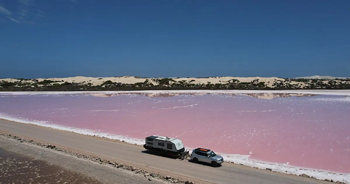 Caravan being towed on a remote road highlighting long-distance towing safety